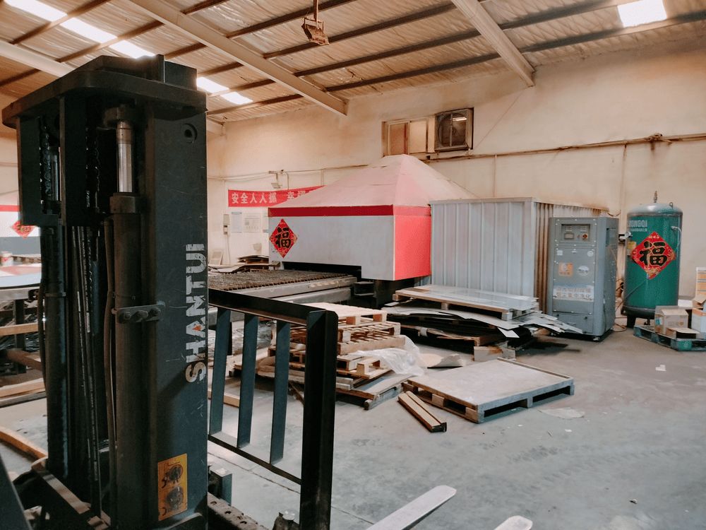 Laser-cut steel components stacked after cutting, ready for bending stage