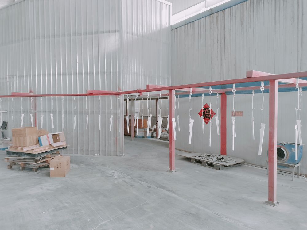 Overhead conveyor belt transporting parts through the powder coating line